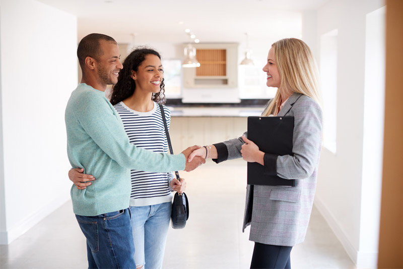 Couple shaking hands with mortgage professional